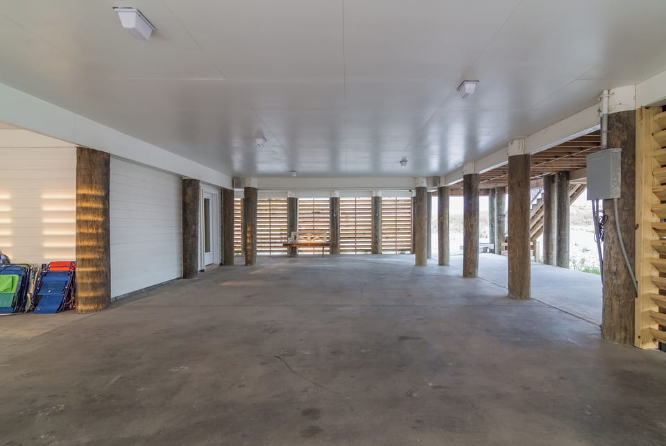 Large open space under the house designed without pilings to interrupt the space
