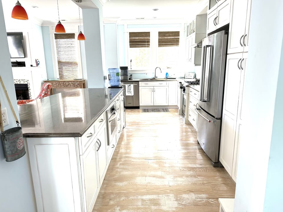 Kitchen hosts all modern appliances, gas cooktop, coffee maker, blender, crock
