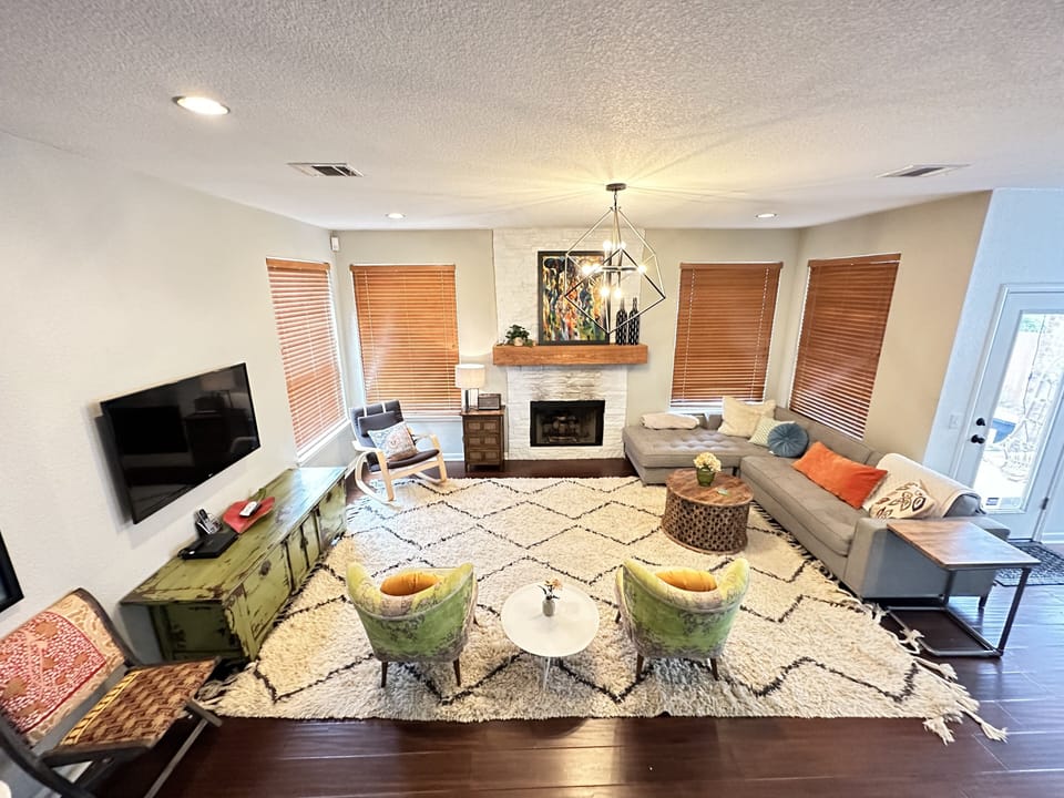 Spacious living room with smart TV and fireplace. Opens up to kitchen and dining