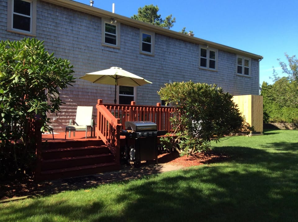 Back of house with gas grill, outdoor shower and 
furniture. 