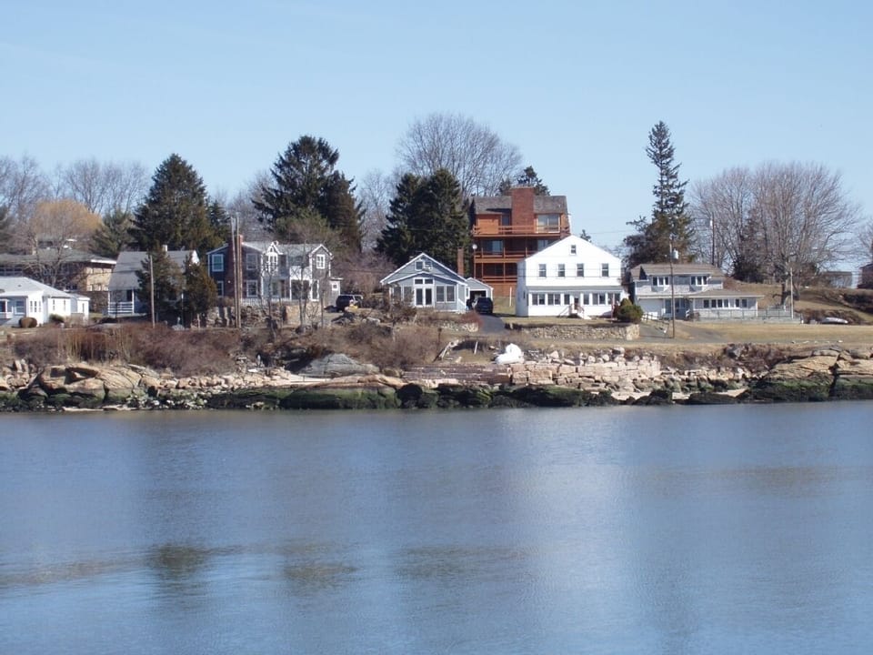 Seaside cottage on the bluff, small grey house in the middle.