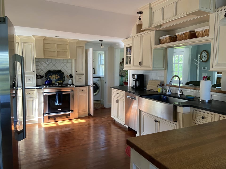 Chef's kitchen with stainless steel appliances, limestone counters and farm sink