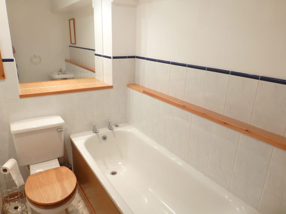 The bathroom with bathtub is opposite the second bedroom