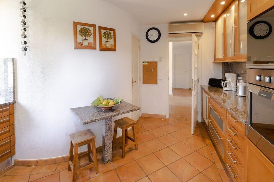 Spacious kitchen with wooden cabinetry and granite countertops — Villa Sara, holiday villa in Loulé