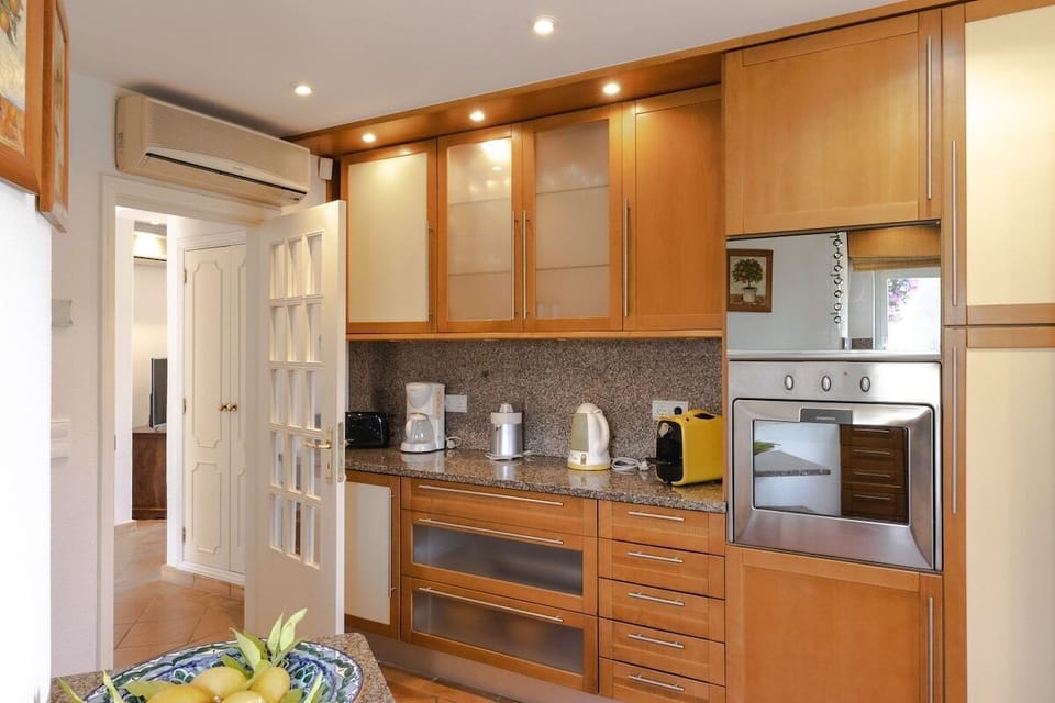 Modern kitchen with wooden cabinetry and granite worktops — Villa Sara, holiday villa in Loulé