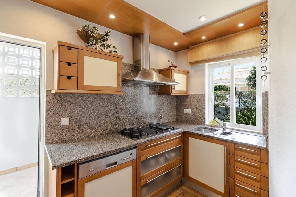Modern kitchen with granite countertops and wooden cabinetry — Villa Sara, holiday villa in Loulé