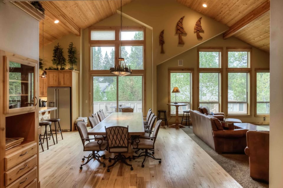 Bright dining area w/ tall windows, rustic table & mountain lodge charm