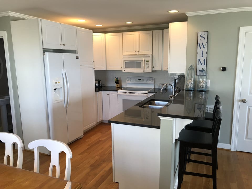 fully stocked kitchen with bar seating for 3