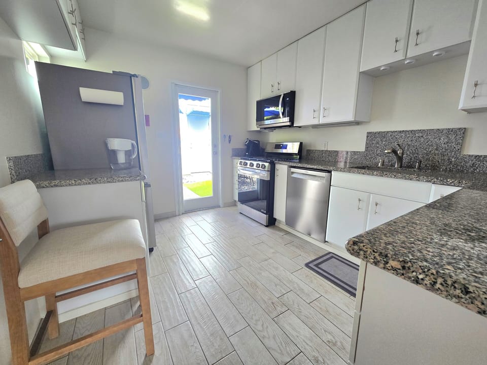 Fully-equipt kitchen with granite counterops and full size appliances