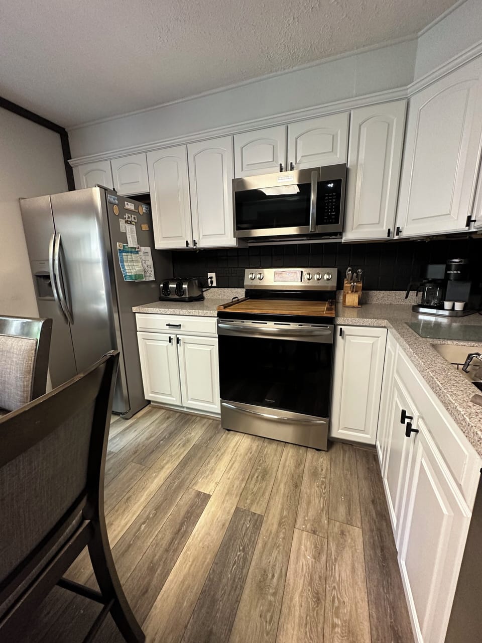 Kitchen with brand new range (with air fryer) and microwave.