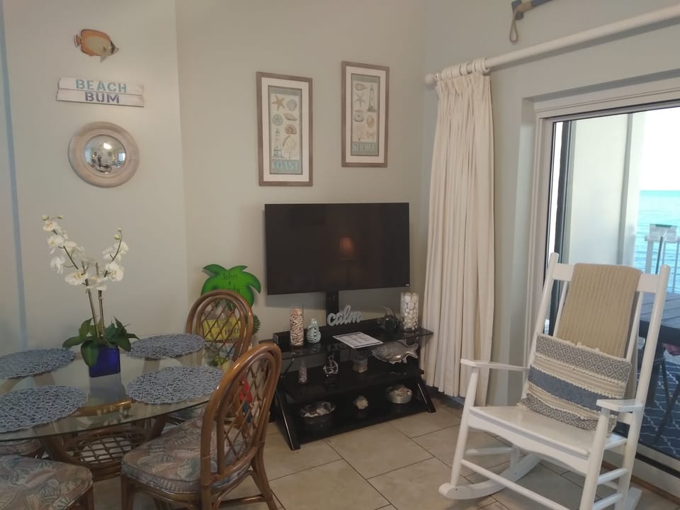 Dining/Living area with flat screen TV by sliding glass door to balcony
