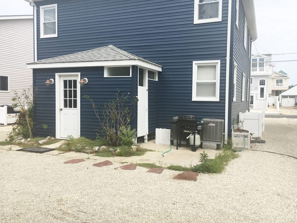 back of house; shared laundry room and outdoor shower ; 2 grills, central AC