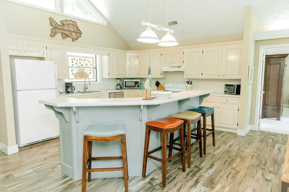 Open kitchen with lots of cabinet and counter space, and large breakfast bar