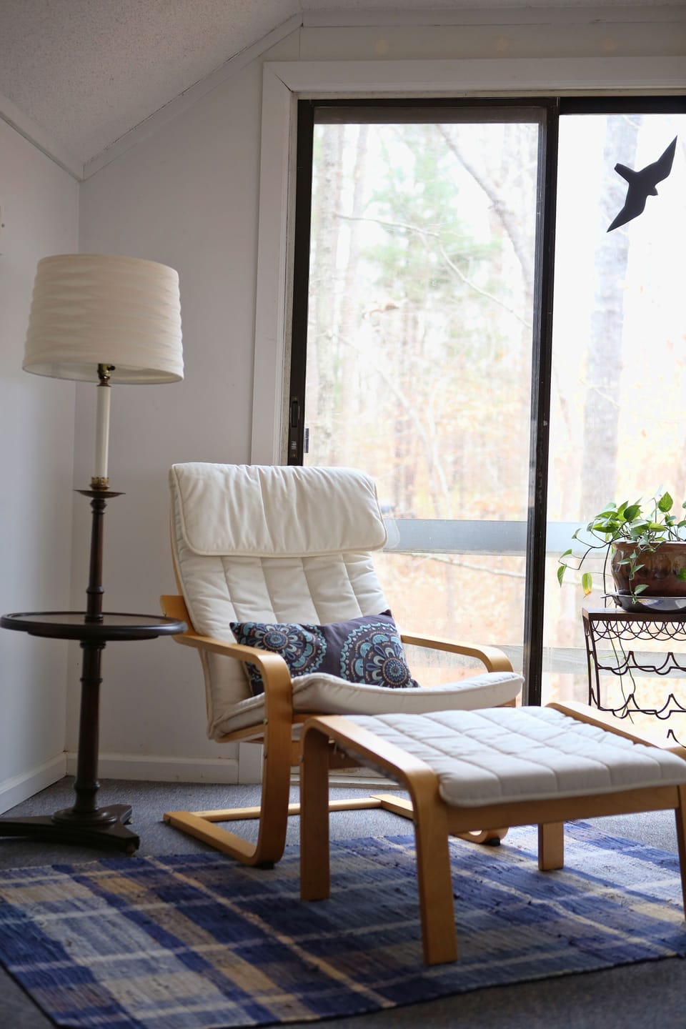 Reading nook in loft next to large sliding door window. 