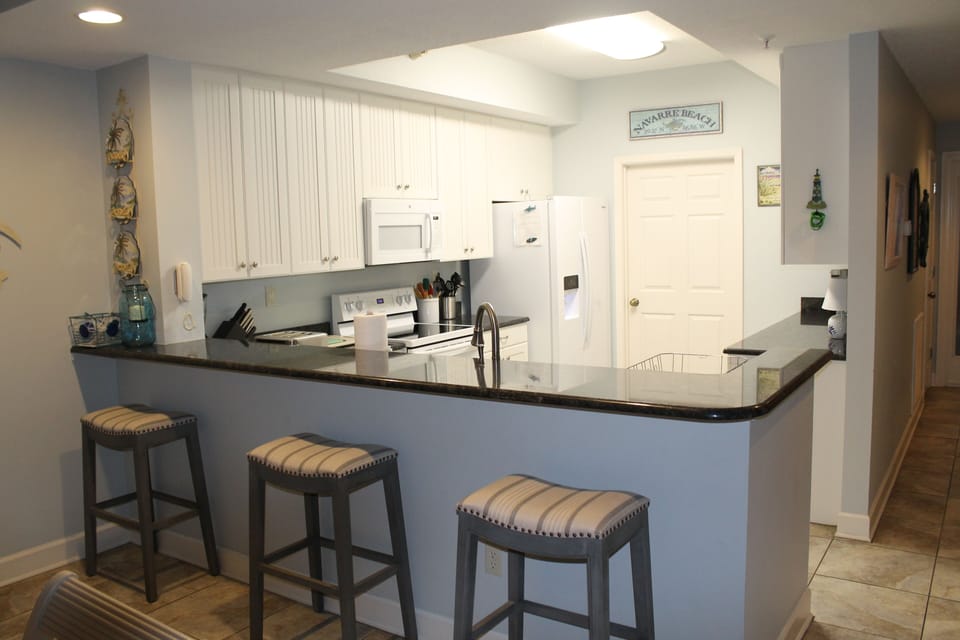 Bar area and kitchen.  Laundry room door is at the far side of the kitchen.  