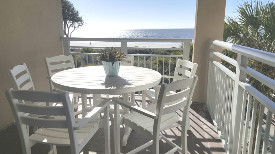 Balcony off living room with ocean view  and seating for six