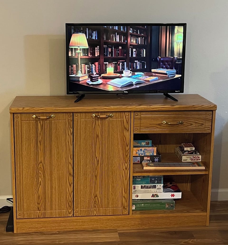 Game room 32” TV with Roku, games, puzzles, electronic darts, wet bar.