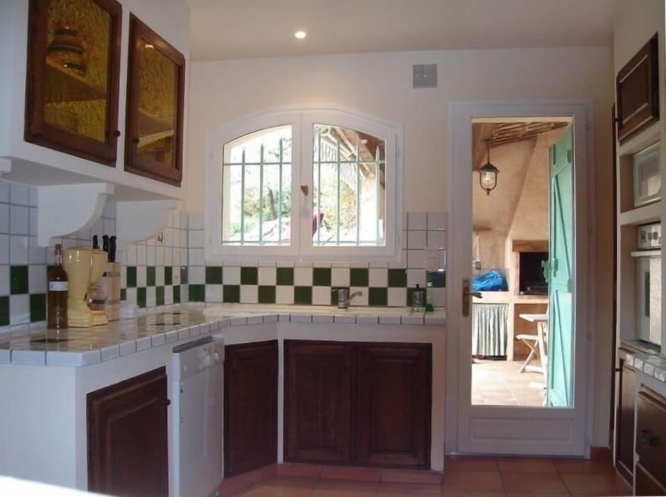 Well-equipped kitchen leading to outdoor eating area and built-in bbq.