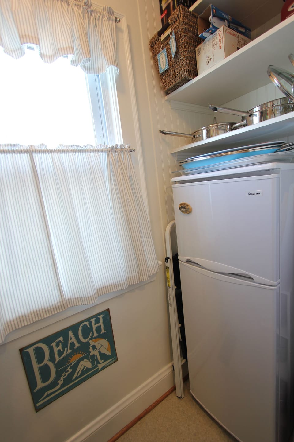 Well stocked and organized pantry with auxiliary beverage refrigerator.
