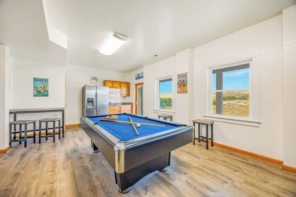 Challenge your friends to a game on the billiards table while soaking in the wide-open landscape views through bright windows that frame the peaceful scenery beyond.