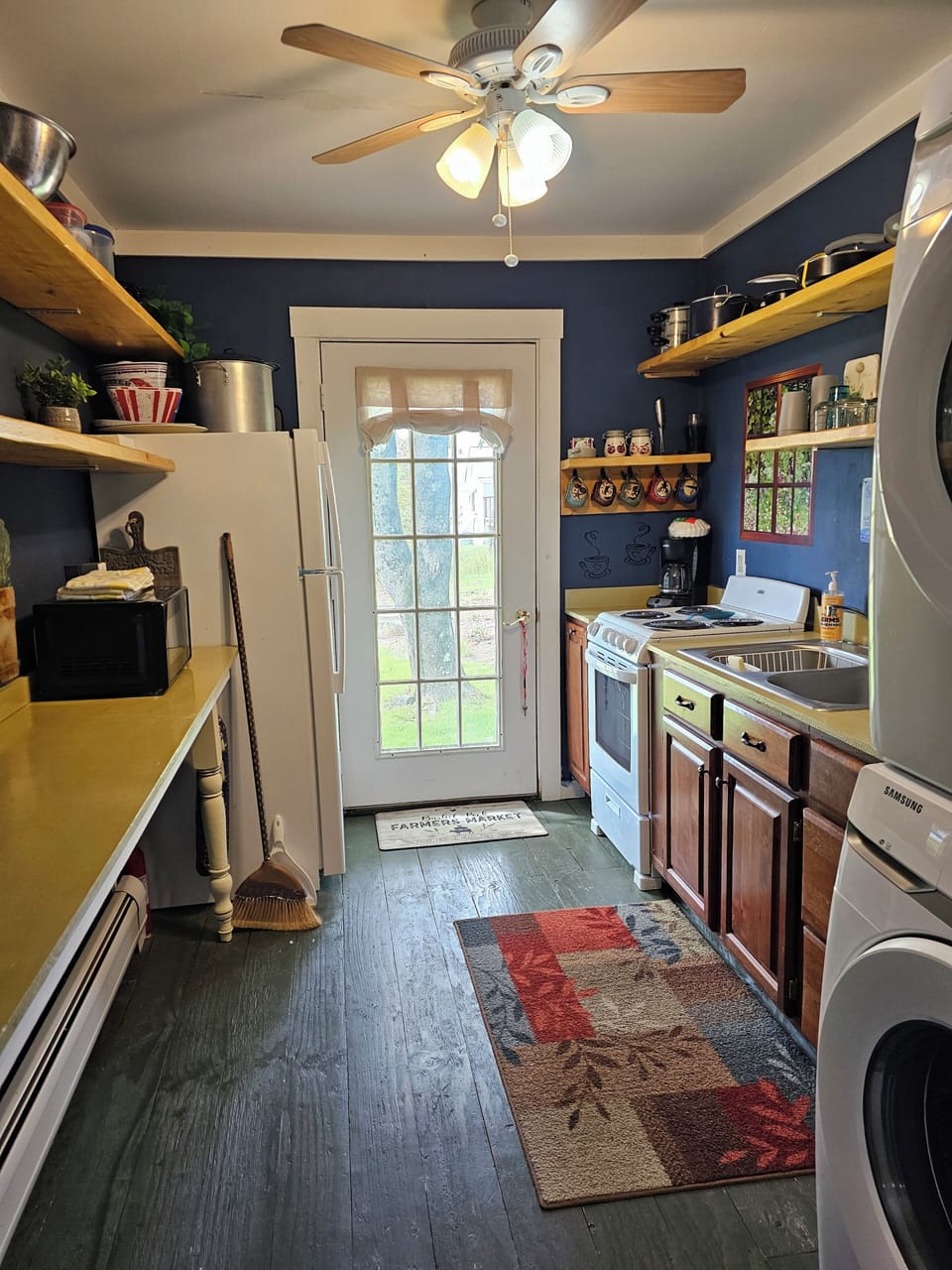 View of kitchen from dining room. Door to side yard with Grill & picnic table.