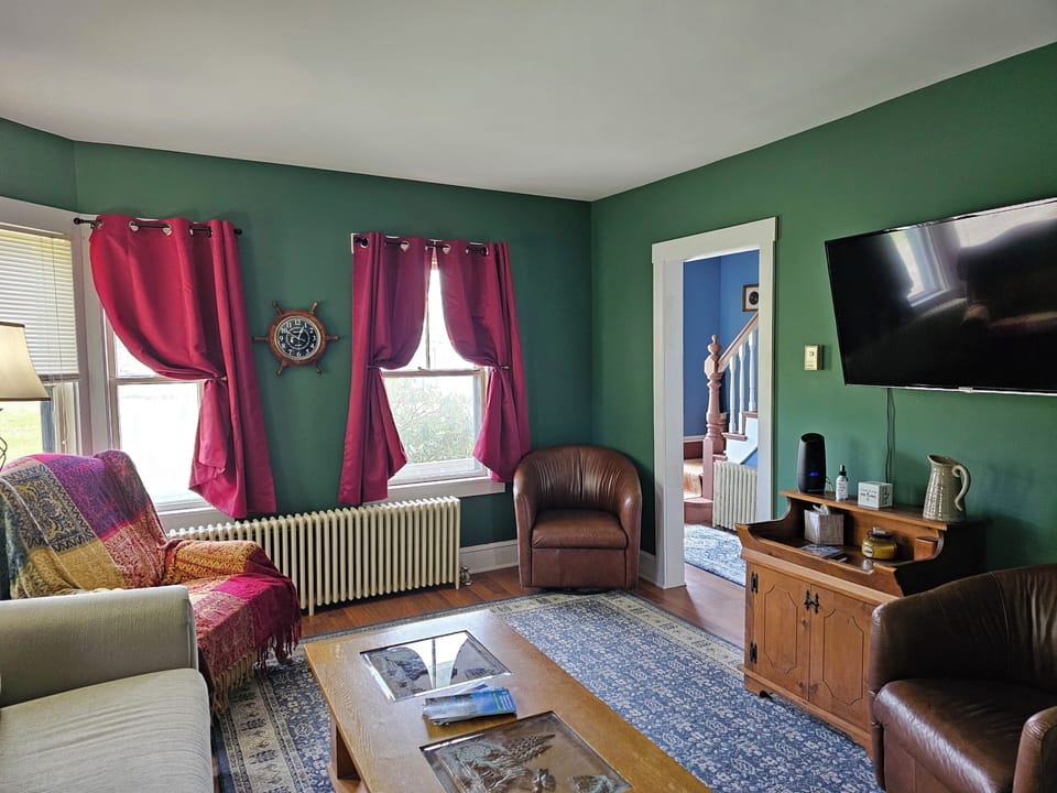 Living room- with pull out sofa, recliner and swivel chair. Flat screen TV