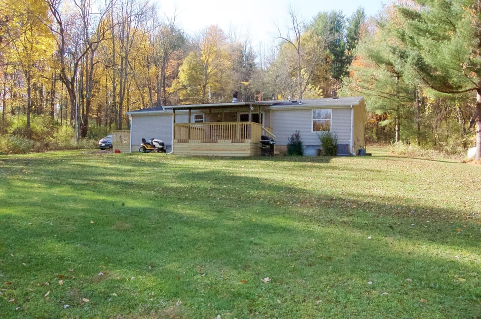 View from back showing covered porch and gas grill.