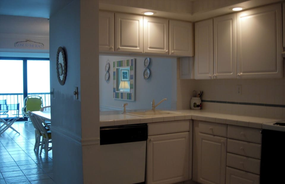 Kitchen with opening that allows view of ocean from kitchen. 