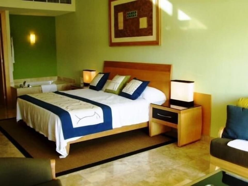 Bedroom with tub in corner and loveseat on side.
