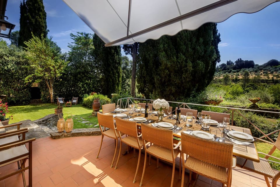 Terrace with motorized Awning and Teak dining table, overlooking the garden and pool area