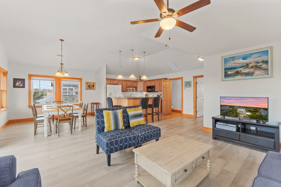 The spacious great room encompasses a comfy living area, well-equipped kitchen, and inviting dining area.