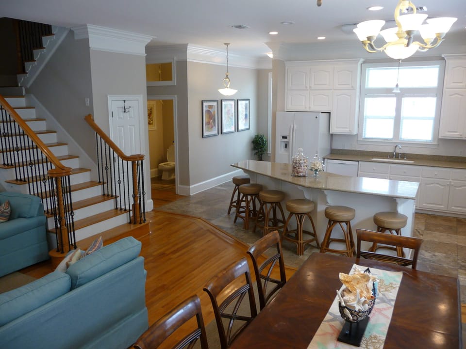 Open concept kitchen, dining, and living room with half bath off of foyer