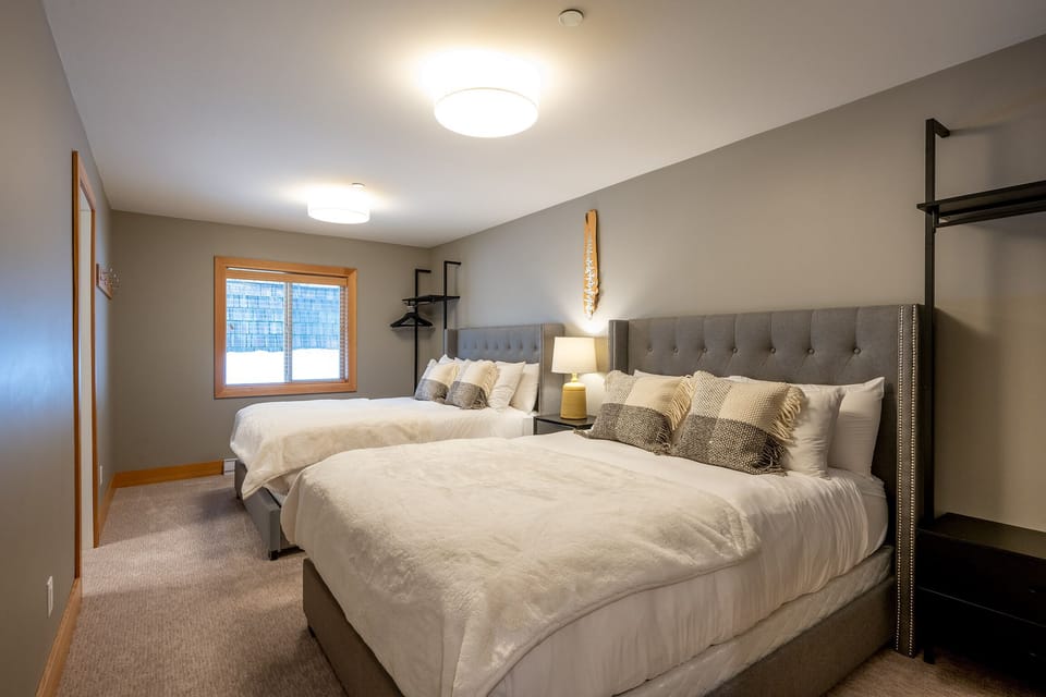 One of the bedrooms with x2 queen beds and an ensuite bathroom