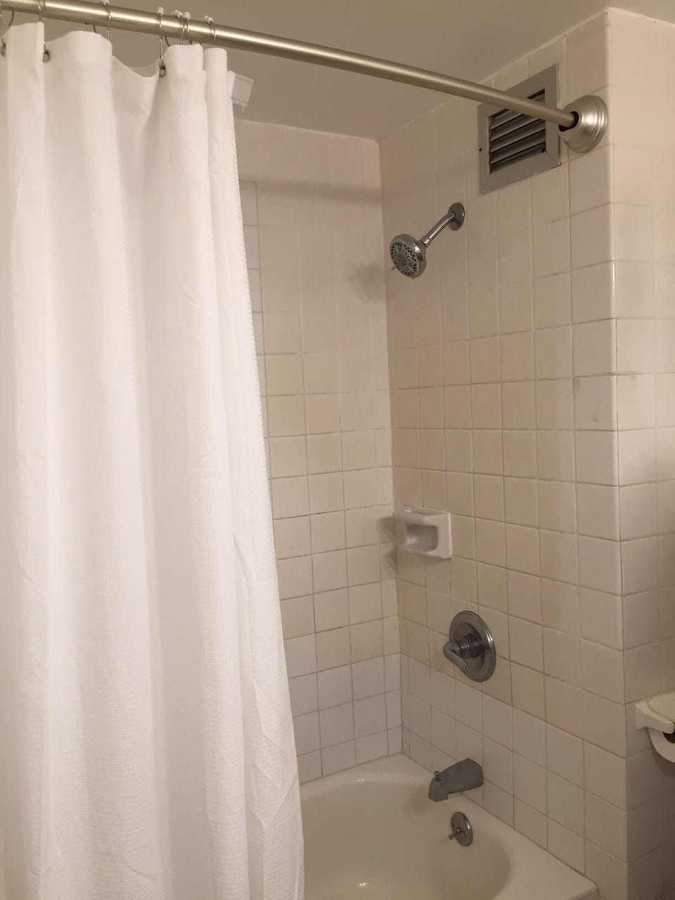 Shower with bowed shower curtain.