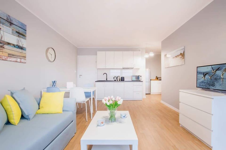 Another angle of the living area, showcasing the sofa and coffee table setup, with stylish decor and a soft color palette that enhances the room's brightness.