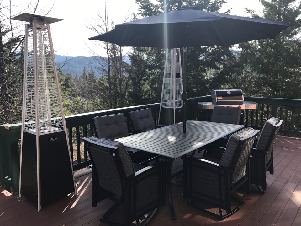 Large deck with dining table, fire pit, heaters and comfortable deck furniture
