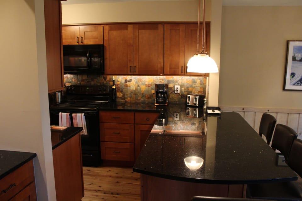 The breakfast bar with beautiful slate backsplash in our custom kitchen.