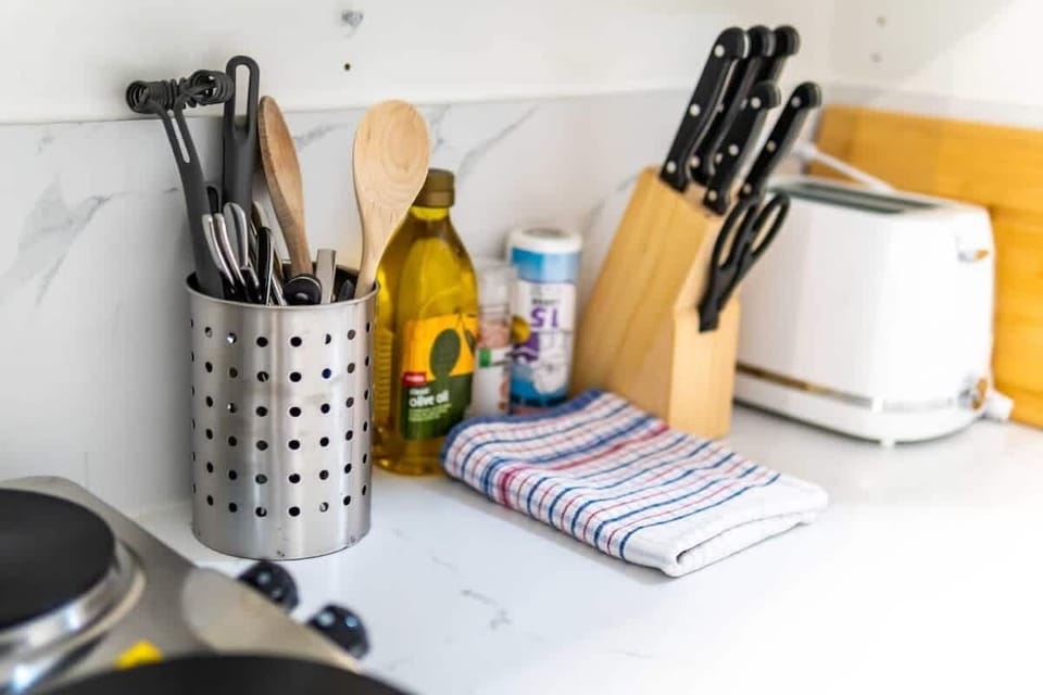 Whip up a delicious meal! Our kitchen is thoughtfully stocked with essential cooking utensils, a full knife set, a toaster, and even olive oil and spices, ready for your culinary creations.