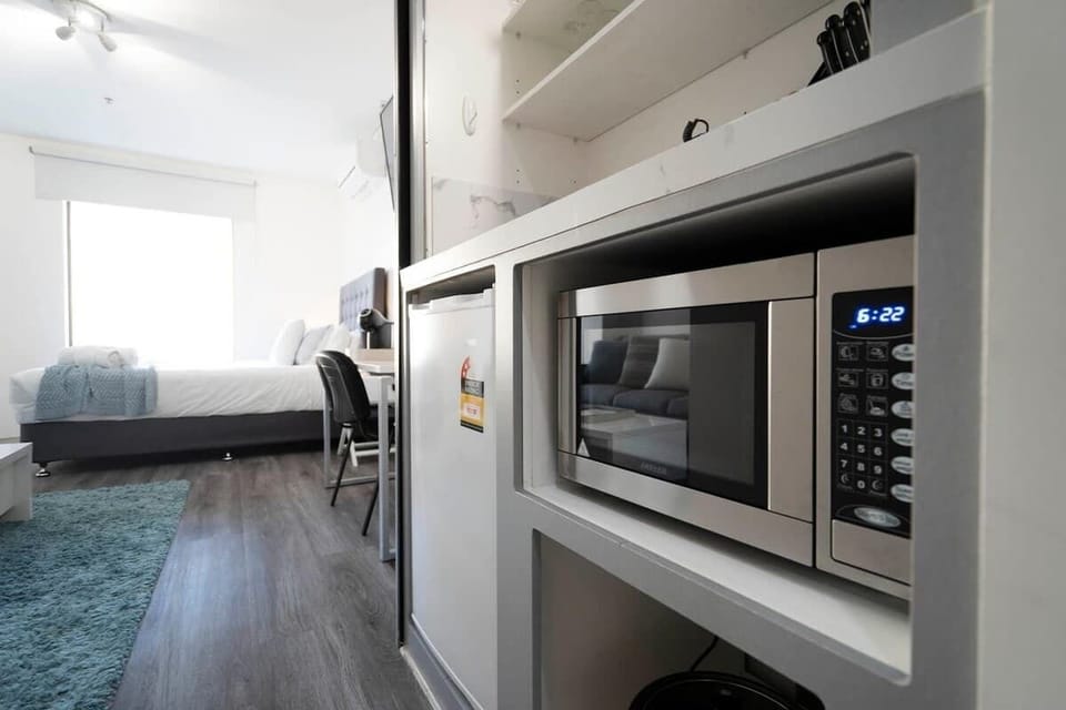 Smart design meets comfort! Enjoy the ease of in-room dining with a microwave and fridge, just steps away from your cozy bed.