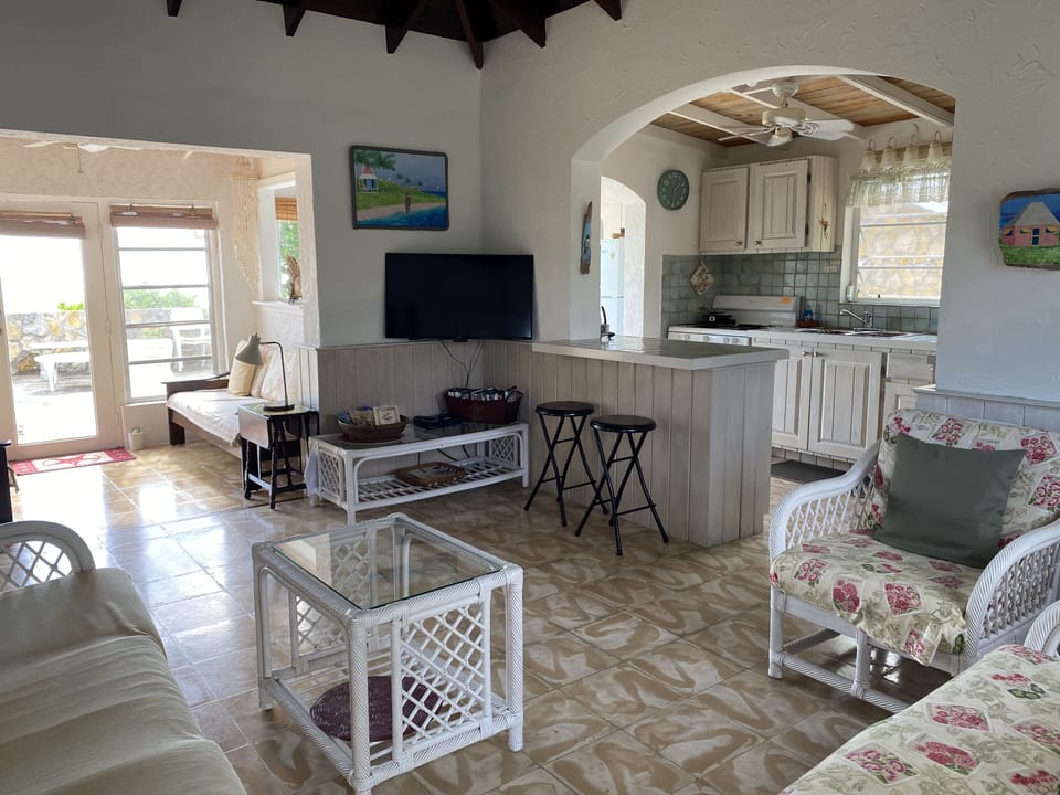 Sun room beyond front room with more seating, nice for a quiet break. 