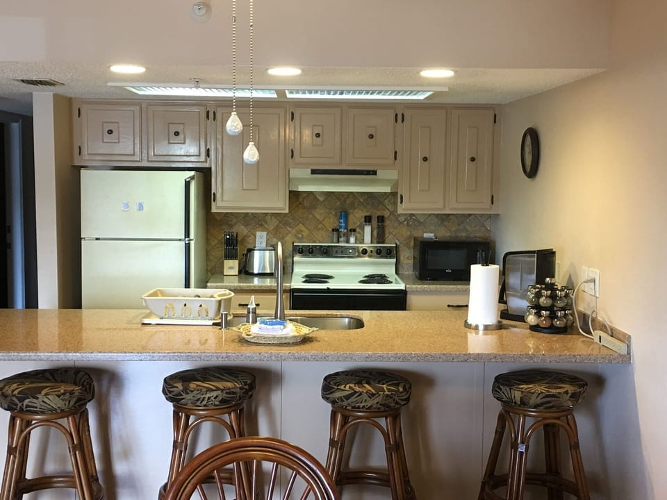  Barstools, kitchen counter refrigerator stove microwave coffeemaker spices etc. 