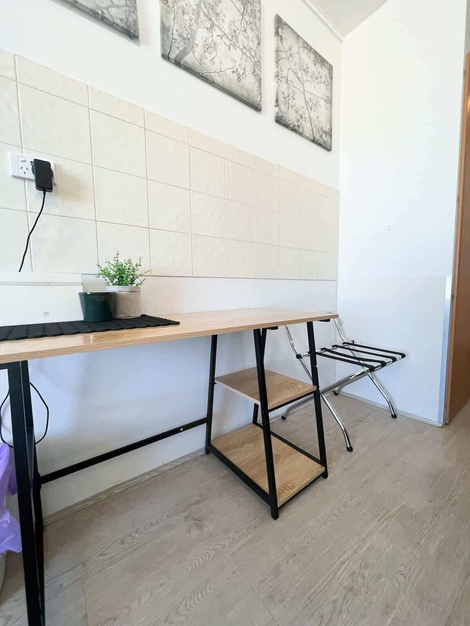 Enjoy a functional and tidy space perfect for your travels. This area features a convenient table, storage shelves, and a foldable luggage rack to keep your belongings organized during your stay.