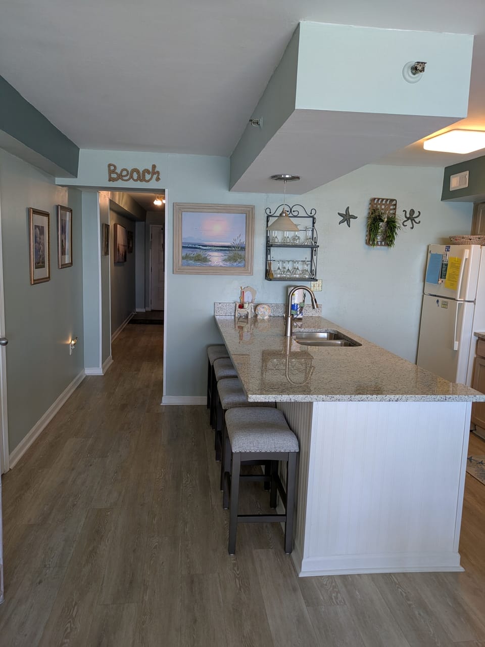 Kitchen and bar area with view of hallway to 2nd bedroom suite. 