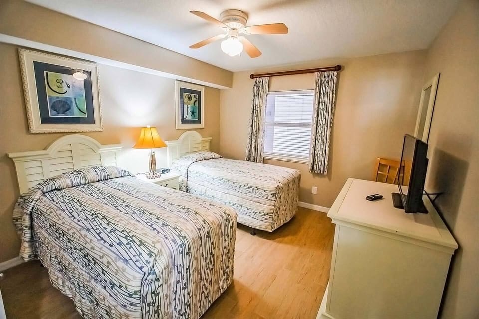 Guest bedroom with two twin beds and tv