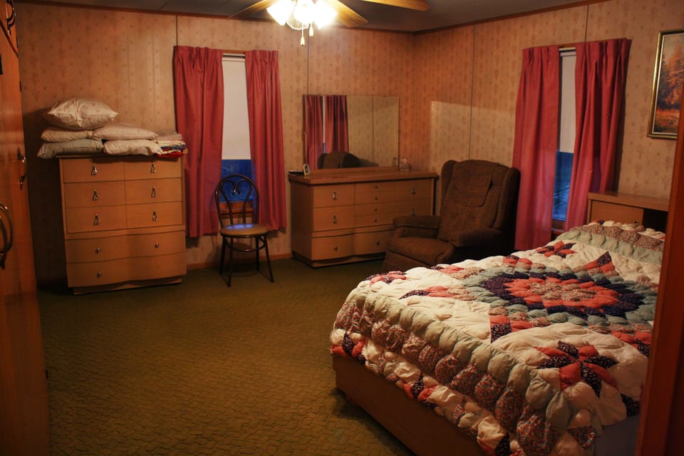 Master BR. Bath is to right. Large closet. Vintage mirrored dressers and bed. 