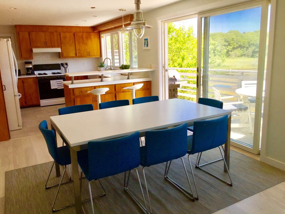 The dining room table seats eight in comfortable leather chairs.