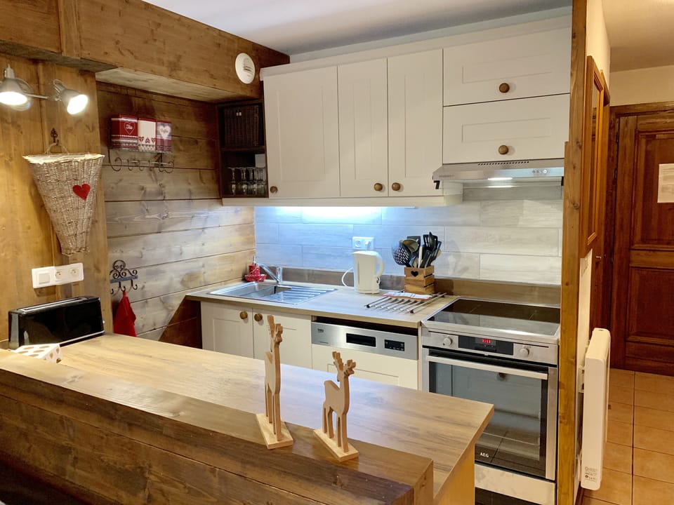 Kitchen with AEG cooker,  oven, induction plates, dishwasher, kettle , extractor