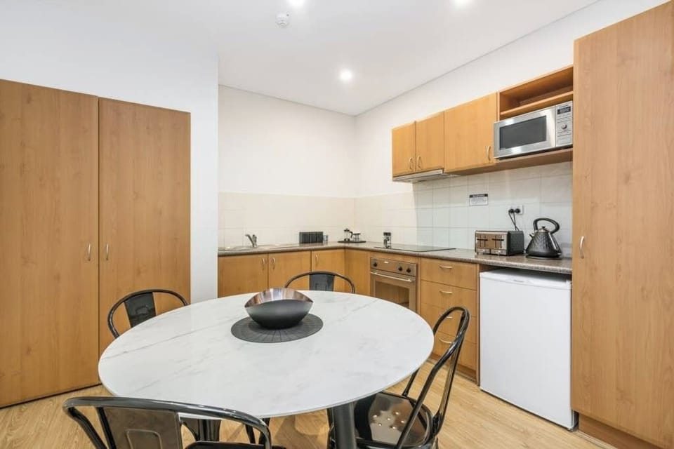 Fully equipped kitchen with modern appliances and a sleek dining area perfect for enjoying home-cooked meals.