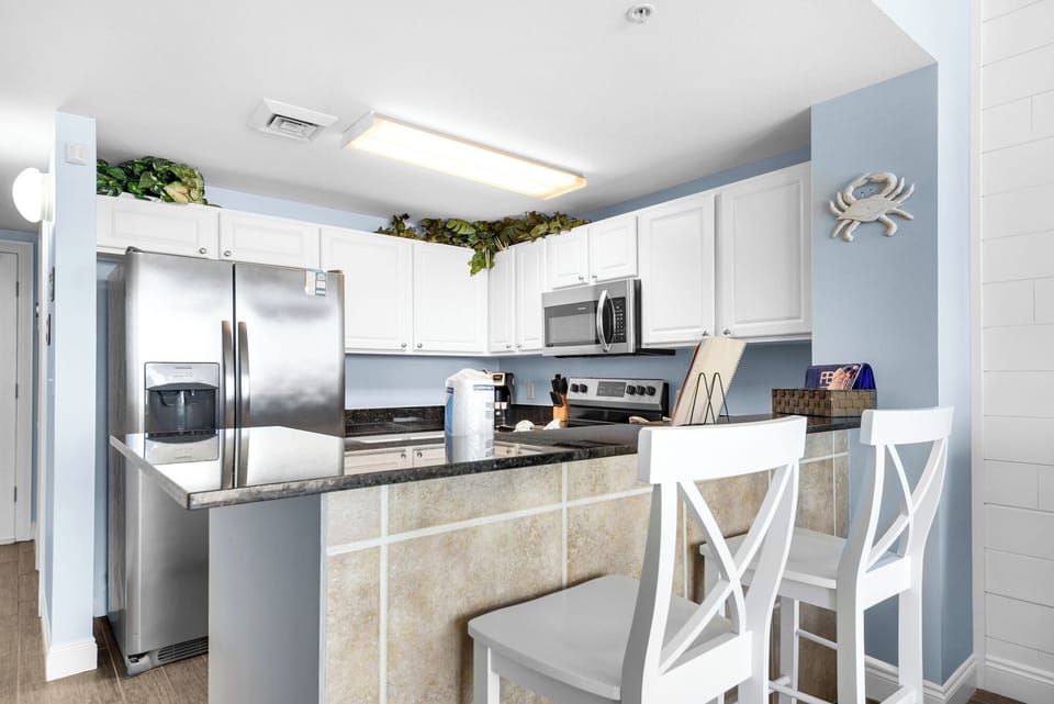 Dining Area - Gather loved ones around this cozy dining space for two, where each meal is elevated by serene beach views and natural light. Included are 2 bar seats for extra seating.