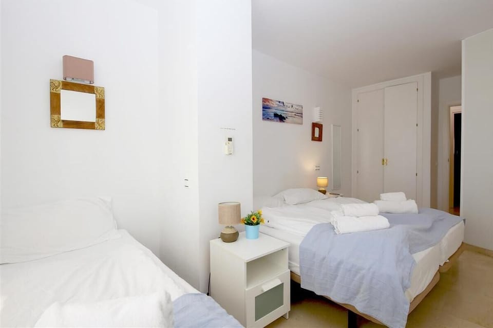 Another picture of the second bedroom with three single beds and built-in wardrobe